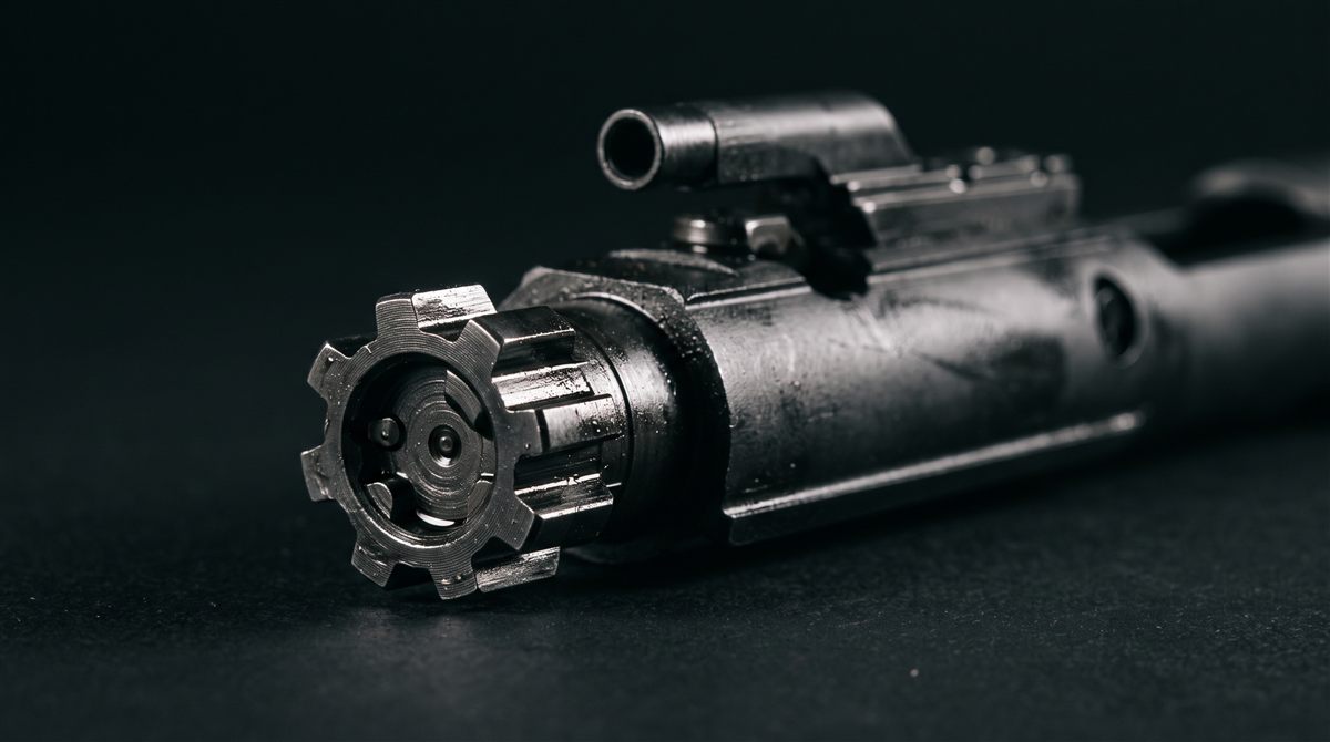 Macro of an AR-15 bolt carrier group, lugs in focus